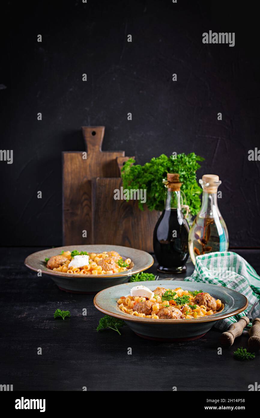 Ditalini tradizionale italiana con polpette in salsa di pomodoro e verdure in ciotola. Ditalini pasta e polpette di manzo con salsa di pomodoro marinara. Foto Stock