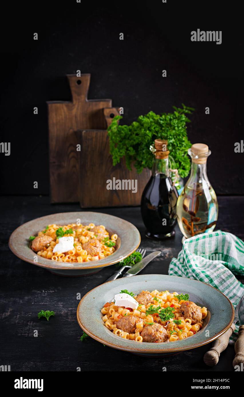 Ditalini tradizionale italiana con polpette in salsa di pomodoro e verdure in ciotola. Ditalini pasta e polpette di manzo con salsa di pomodoro marinara. Foto Stock