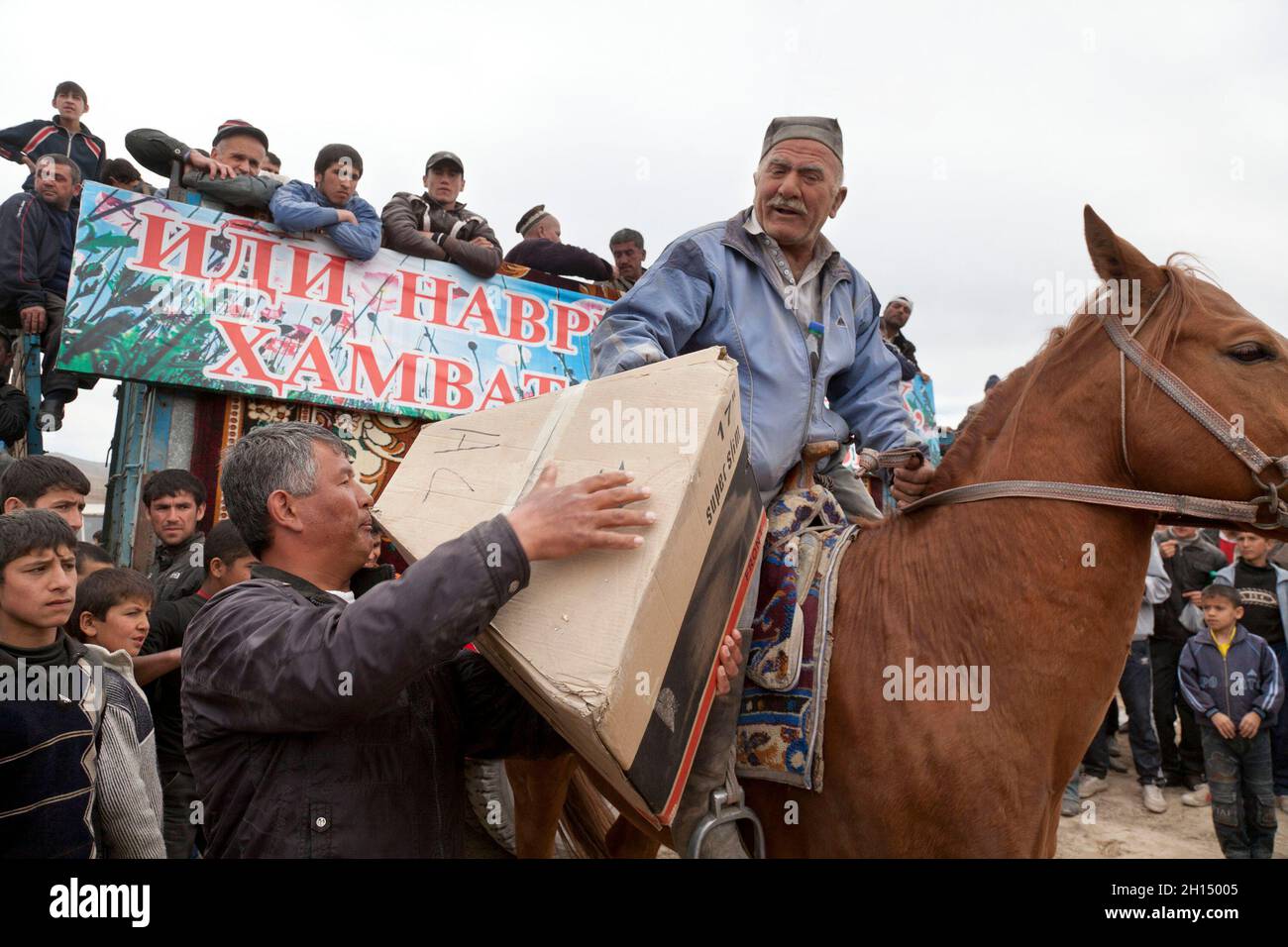 Un senior rider raccoglie i suoi premi tra cui un 17 pollici, TV a una celebrazione Navruz corrispondono, in Qahramon, vicino Hisor, Tagikistan. Foto Stock