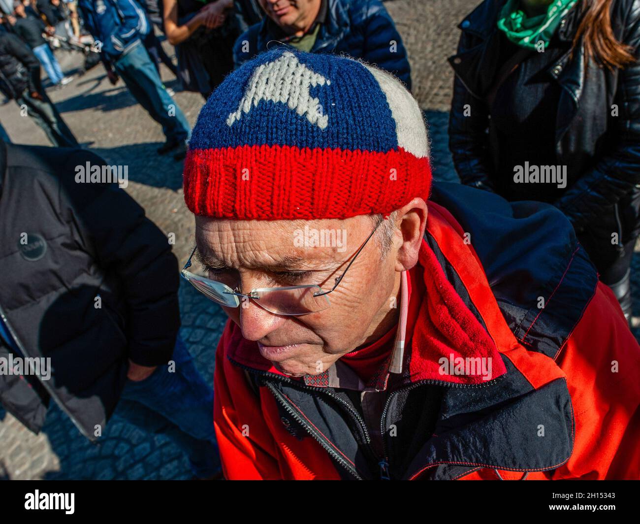 Durante la dimostrazione si vede un uomo che indossa una berretto di lana con la bandiera cilena. Nel secondo anniversario dell'epidemia sociale cilena, diverse organizzazioni sociali, politiche e per i diritti umani con sede a livello europeo si sono riunite per chiedere verità, giustizia, riparazione e garanzie di non ripetizione per le violazioni sistematiche dei diritti umani commesse da funzionari di polizia cileni, appoggiati dal presidente di seduta del Cile, Sebastian Piñera. Ad Amsterdam, la comunità cilena ha organizzato una manifestazione accompagnata da spettacoli e musica cilena nel centro della città. Foto Stock