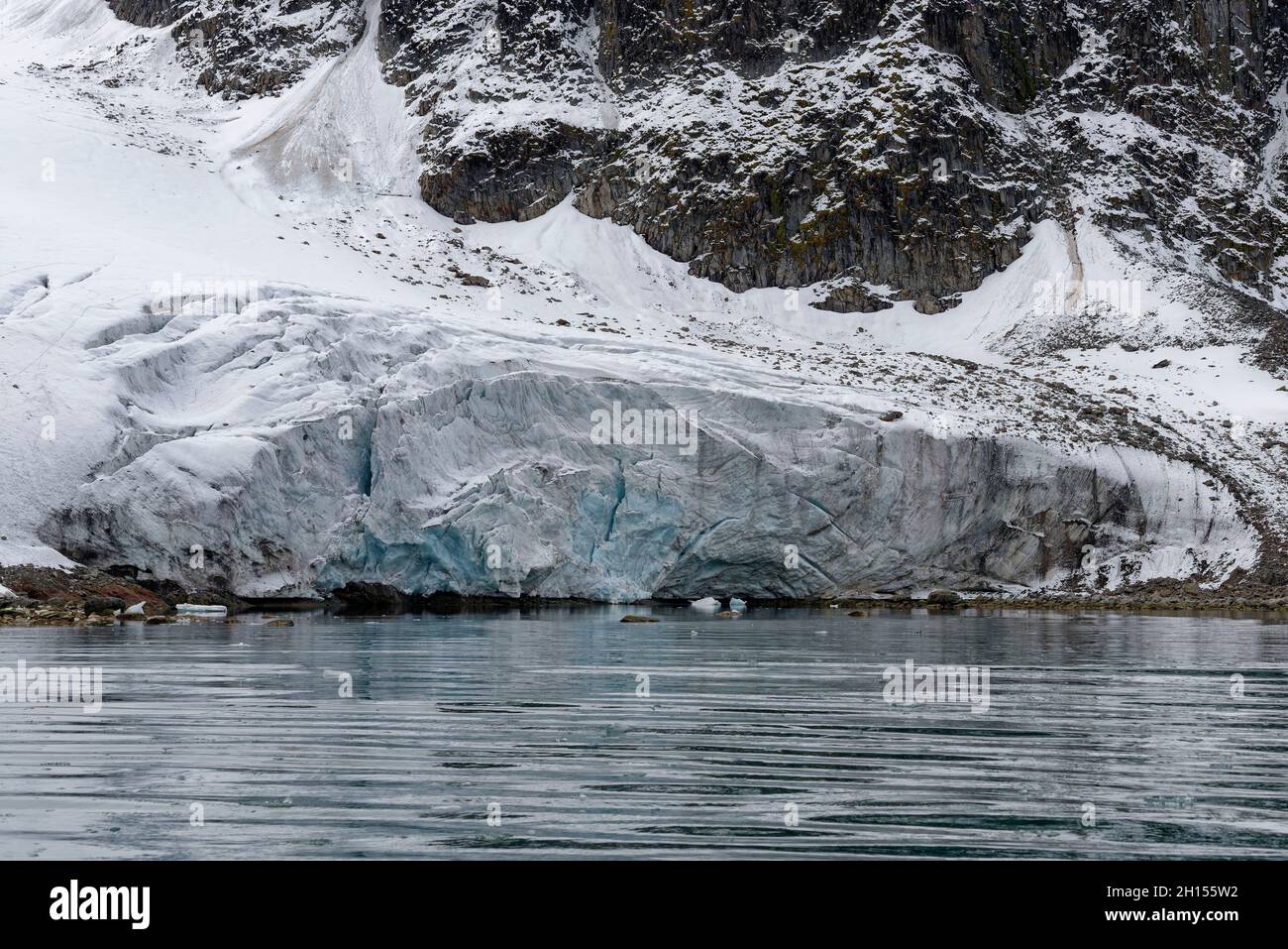 Ghiacciaio fondente ricoperto di materiale eroso. Raudfjorden, Spitsbergen, Svalbard, Norvegia Foto Stock