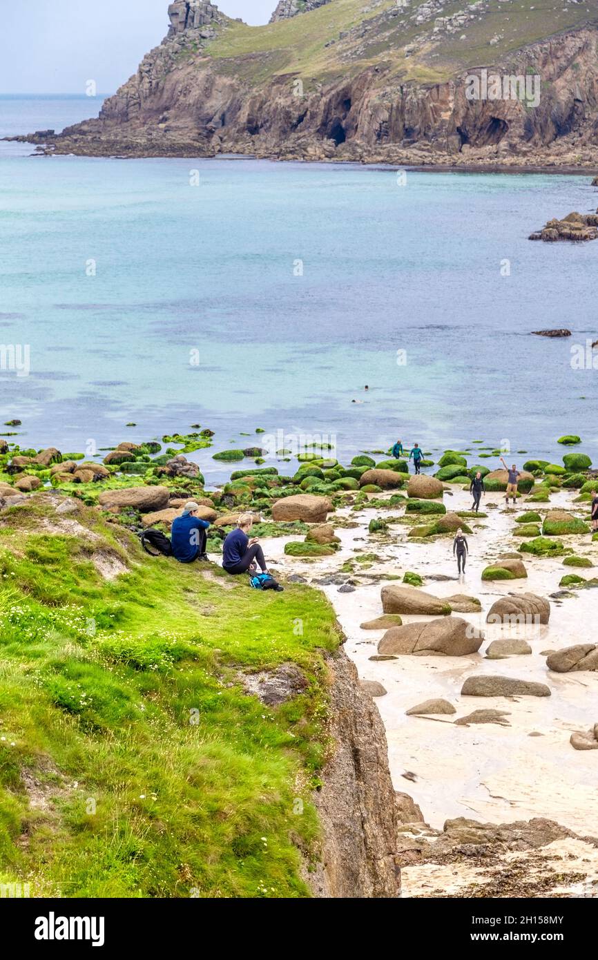 Coppia che prende una pausa pranzo a Nanjizal Beach lungo il South West Coast Path, Cornovaglia, Regno Unito Foto Stock