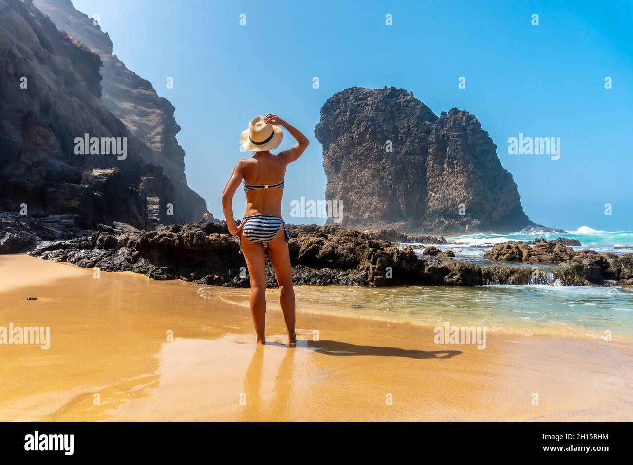 Vista posteriore di una giovane donna a Roque del Moro, spiaggia di Cofete, parco naturale Jandia, Barlovento, Spagna Foto Stock