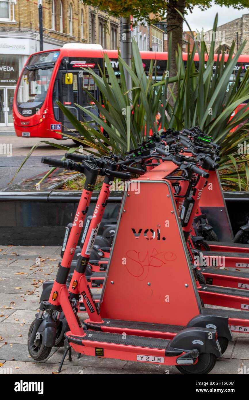 scooter elettrici a noleggio su uno stand nella città di southampton per il noleggio di mezzi pubblici. autobus rossi e noleggio di scooter elettrici nella stessa strada. Foto Stock