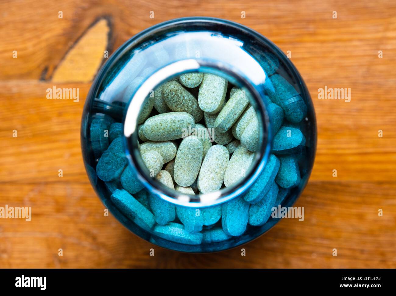 Compresse di vitamina in un flacone blu traslucido dall'alto. Foto Stock