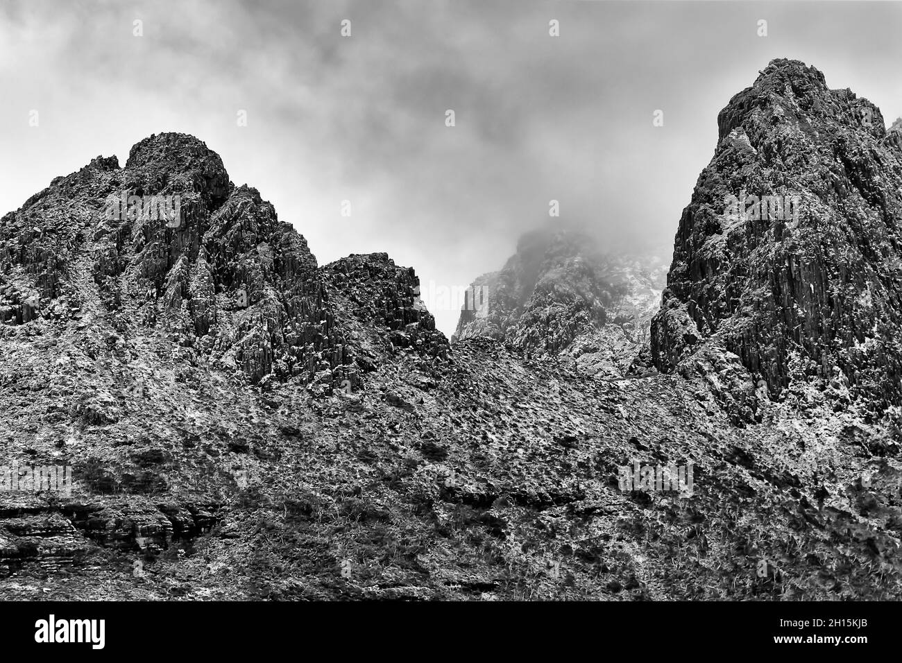 Rocce aspre e invecchiate di tre cime sulla cima del Monte Cradel in un parco nazionale dell'Australia, Tasmania. Impressione a contrasto bianco-nero. Foto Stock