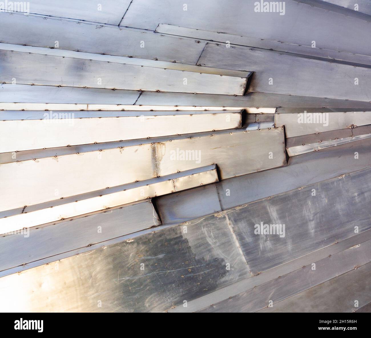 Texture foto di acciaio inox corazzato superfici graffiate con toni caldi e blu. Foto Stock