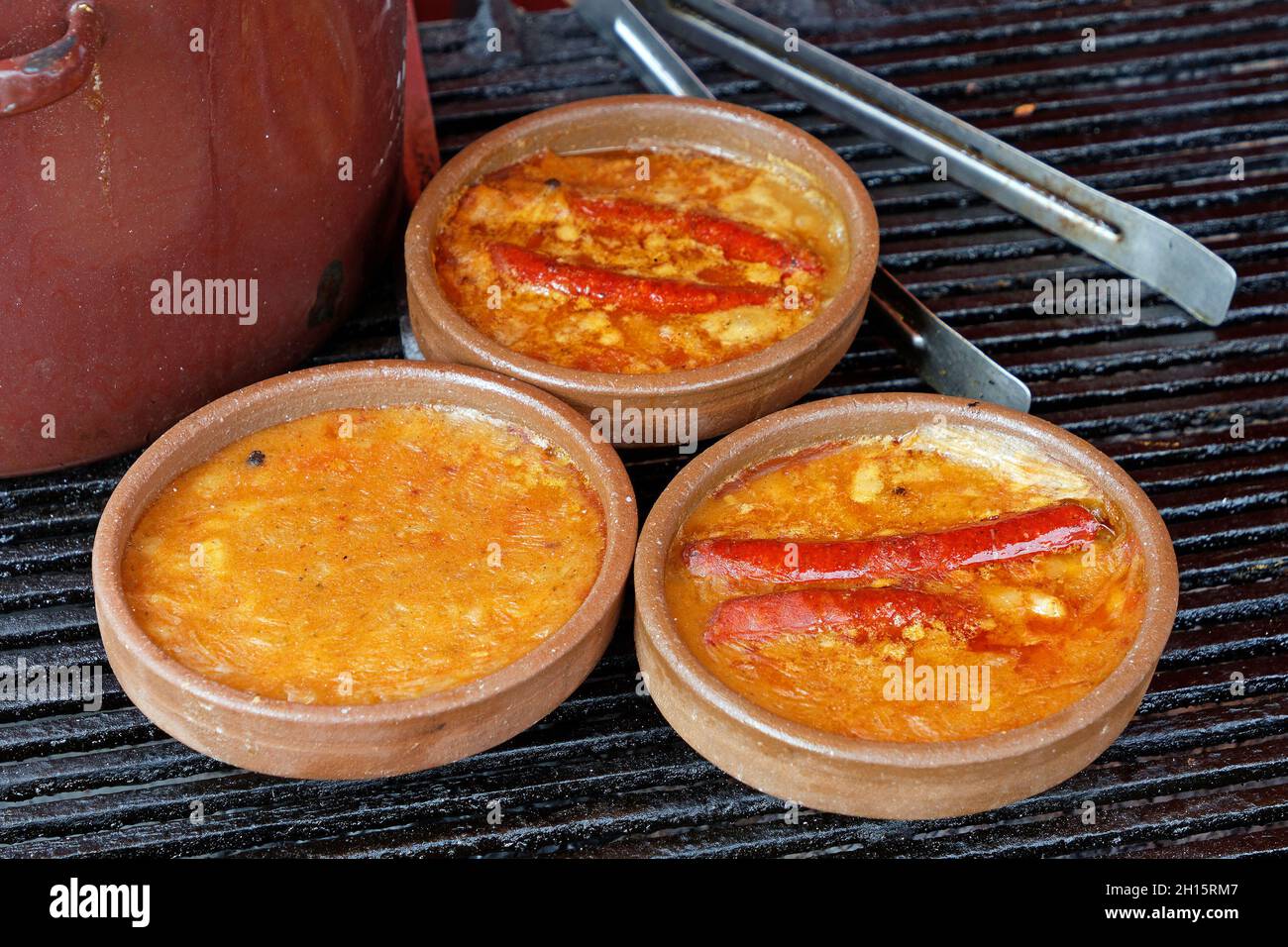 Fagioli e salsicce pasti in contenitori di ceramica venduti sul mercato all'aperto Foto Stock