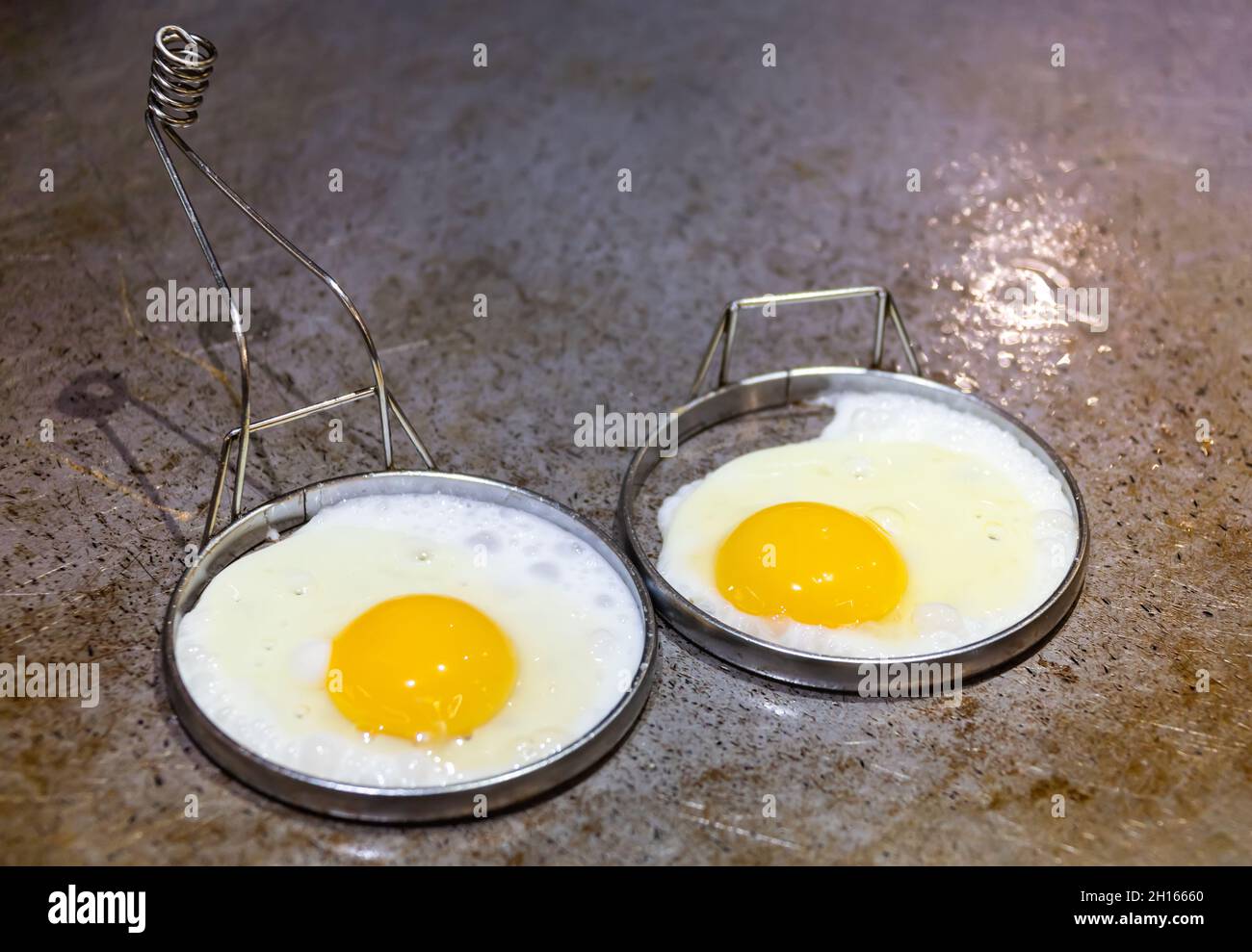 La prima colazione viene servita con poche uova fritte sulla piastra calda Foto Stock