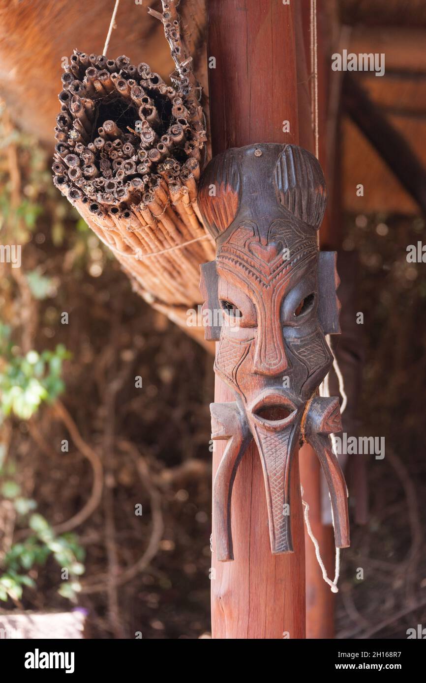 Scultura di maschera africana appesa alla veranda Foto Stock