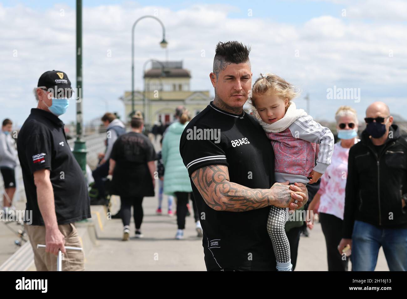 Melbourne, Australia. 17 ottobre 2021. Un uomo porta sua figlia mentre guida uno skateboard elettrico sul molo di St Kilda durante il più lungo blocco del mondo a St Kilda. Il Premier Daniel Andrews ha annunciato oggi un nuovo allentamento delle restrizioni in presenza di un'intensa pressione da parte del NSW e dei sondaggi interni che mostrano un netto calo del sostegno. Credit: Dave Hewison/Speed Media/Alamy Live News Foto Stock