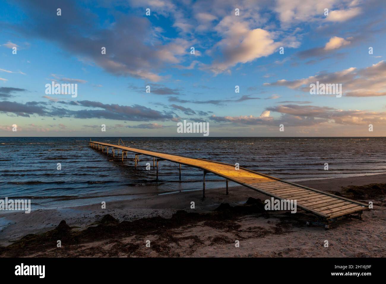 Bacino di legno nell'oceano. Cielo colorato in estate. Foto Stock