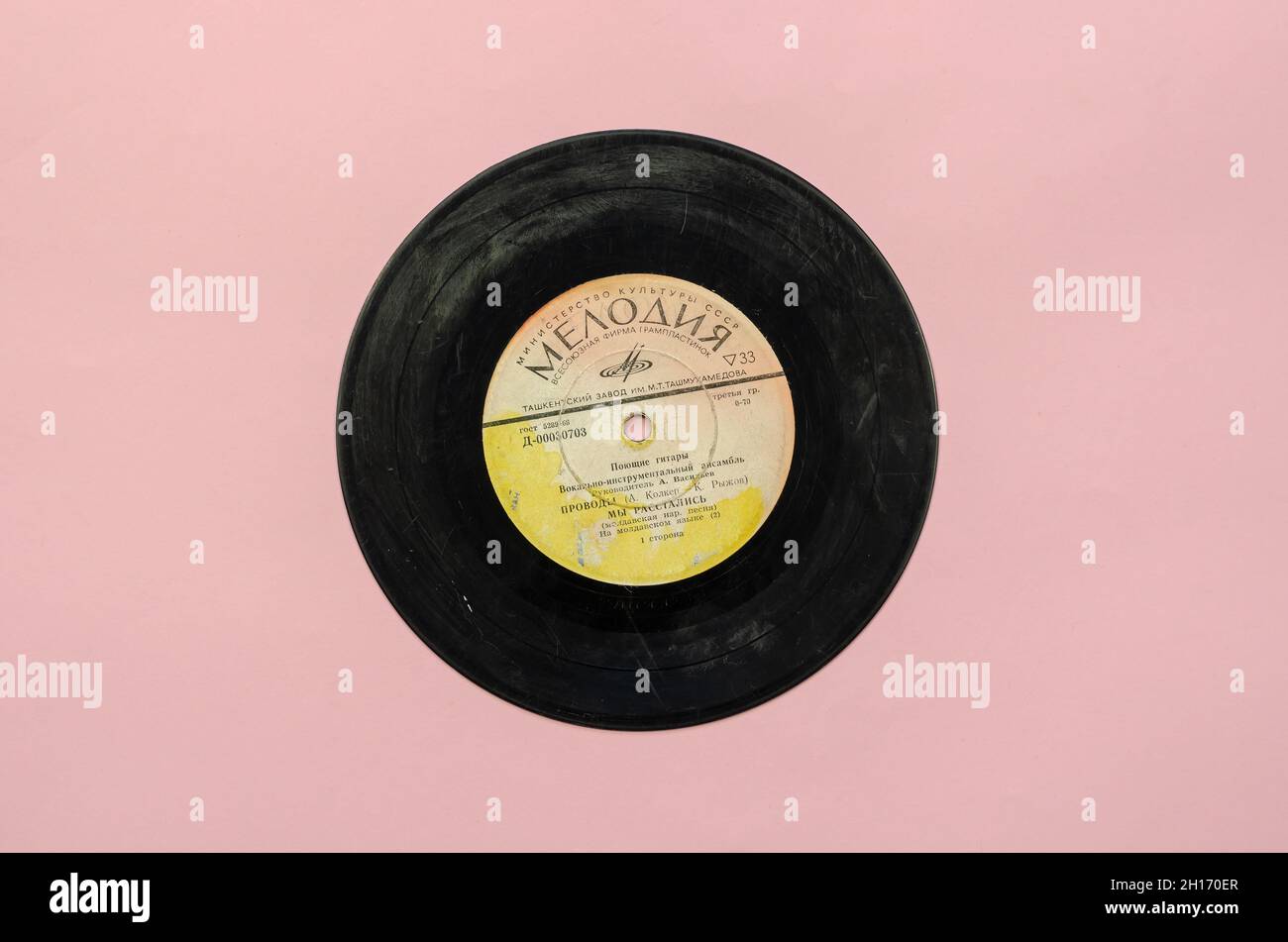 Vinile record degli anni '70. Nero gramophone record su sfondo rosa. Raccolta di canzoni della band sovietica Singing Guitars. Record azienda 'M Foto Stock