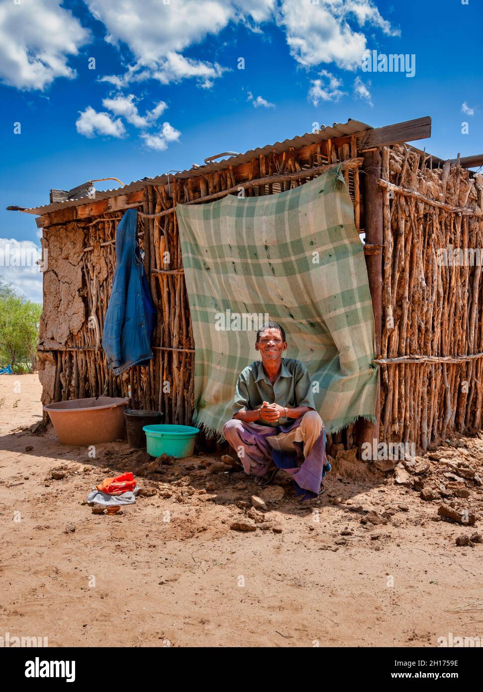Vecchio uomo bushman di fronte alla baracca da Kalahari Centrale, villaggio New Xade in Botswana Foto Stock