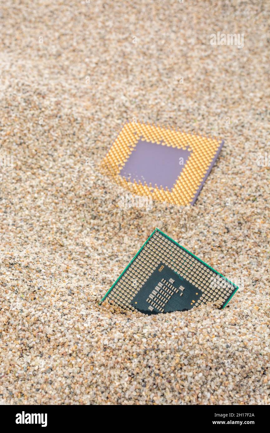 CPU di computer antichi sepolti in un mucchio di sabbia per cimitero di computer, computer legacy. Intel Mobile Computing Merom e AMD Duron cpu presenti. Foto Stock