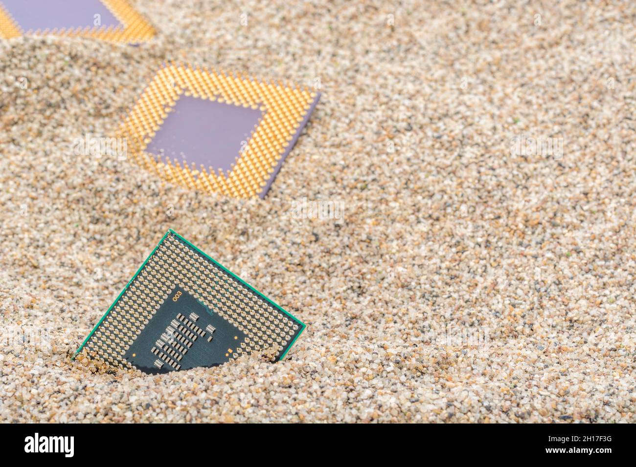 CPU di computer antichi sepolti in un mucchio di sabbia per cimitero di computer, computer legacy. Intel Mobile Computing Merom, AMD Duron e CPU K6 presenti. Foto Stock