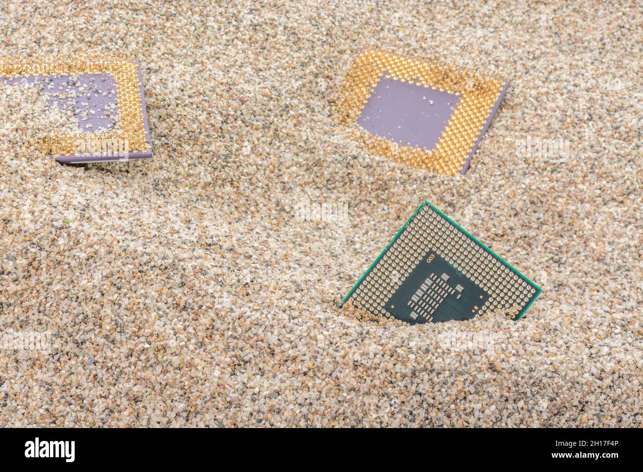 CPU di computer antichi sepolti in un mucchio di sabbia per cimitero di computer, computer legacy. Intel Mobile Computing Merom, AMD Duron e CPU K6 presenti. Foto Stock