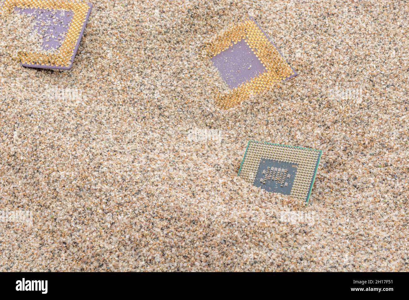 CPU di computer antichi sepolti in un mucchio di sabbia per cimitero di computer, computer legacy. Intel Mobile Computing Merom, AMD Duron e CPU K6 presenti. Foto Stock