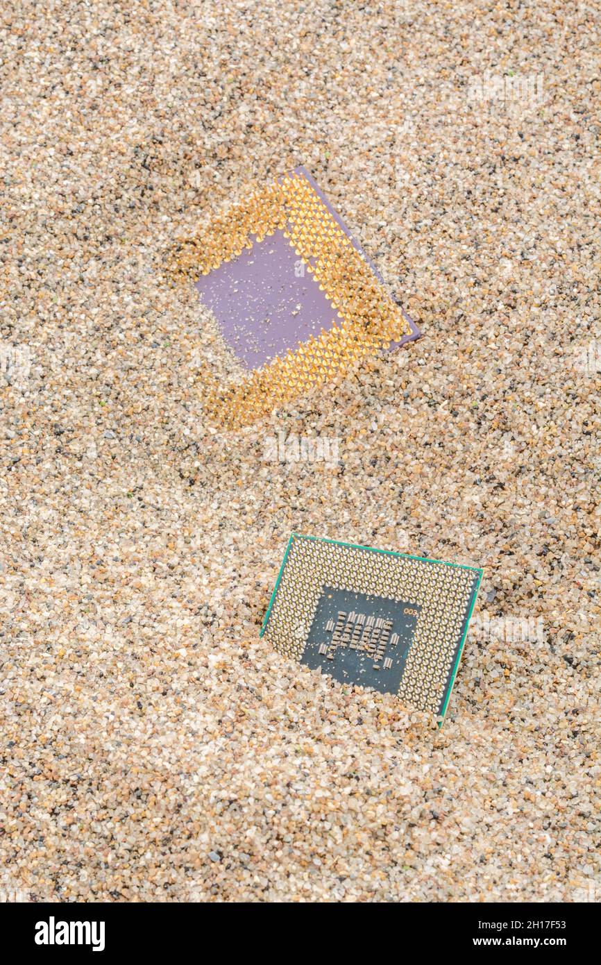 CPU di computer antichi sepolti in un mucchio di sabbia per cimitero di computer, computer legacy. Intel Mobile Computing Merom e AMD Duron cpu presenti. Foto Stock