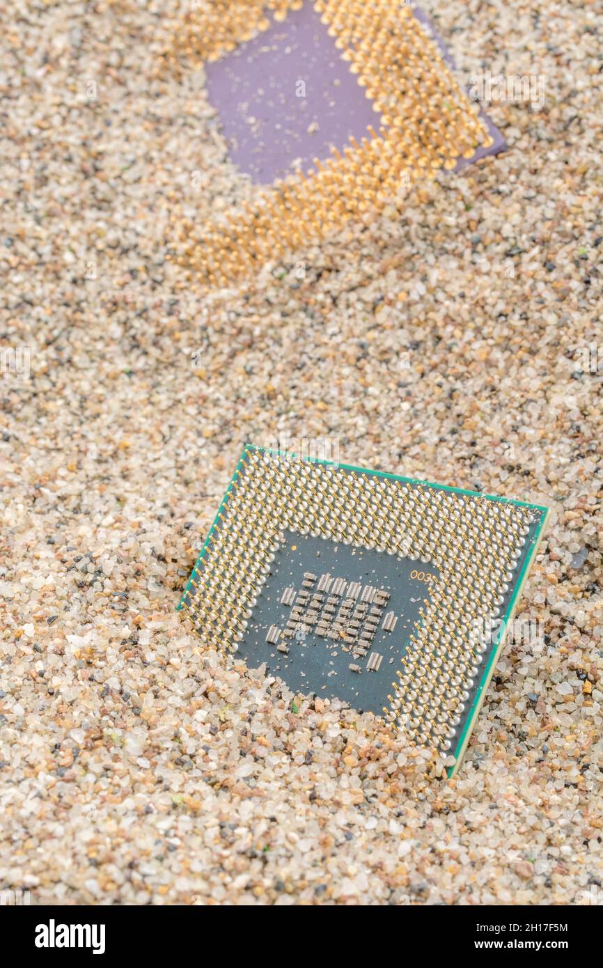 CPU di computer antichi sepolti in un mucchio di sabbia per cimitero di computer, computer legacy. Intel Mobile Computing Merom e AMD Duron cpu presenti. Foto Stock