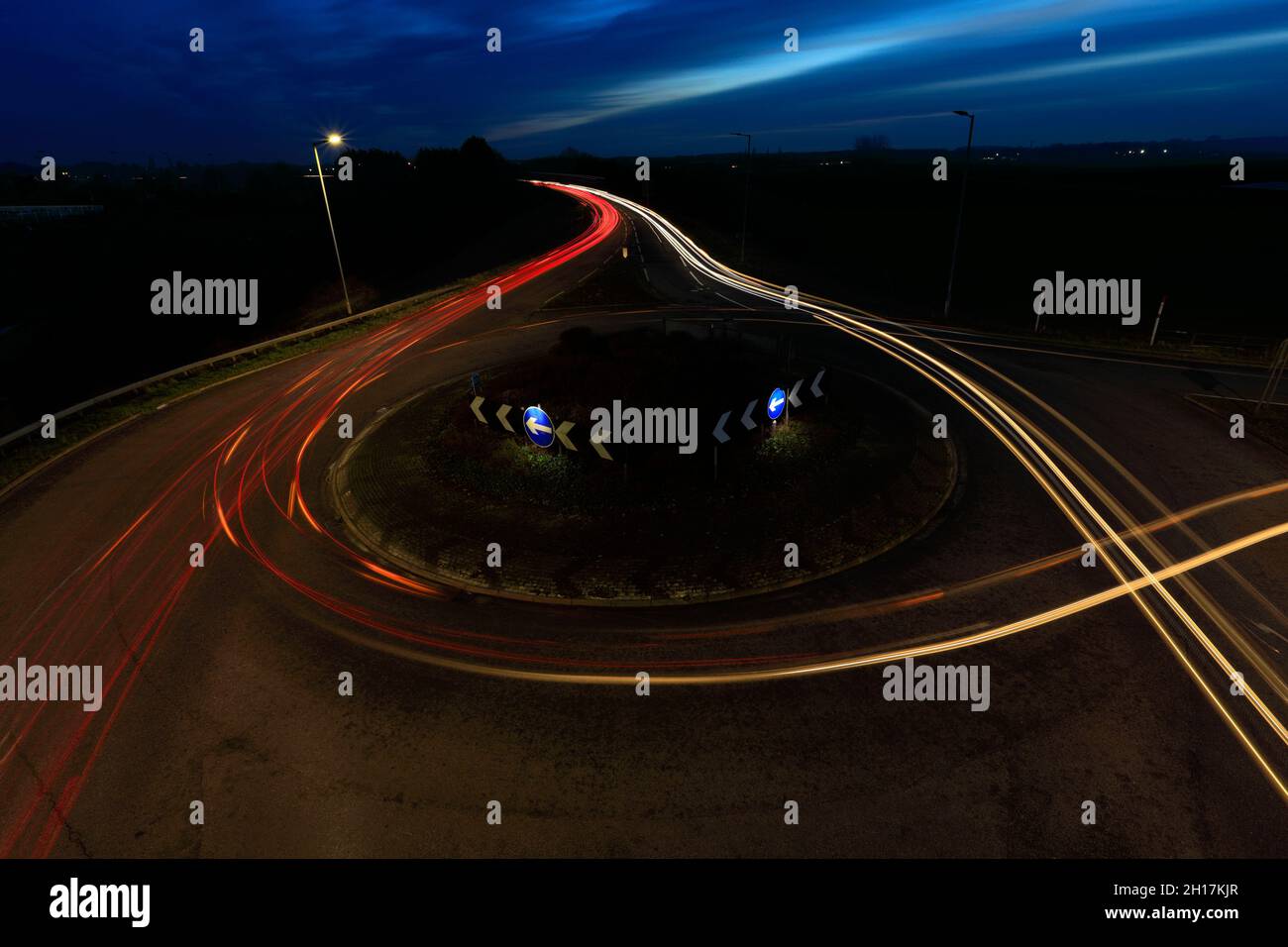 Percorsi per auto notturne a una rotatoria, Peterborough City, Cambridgeshire, Inghilterra; Regno Unito Foto Stock
