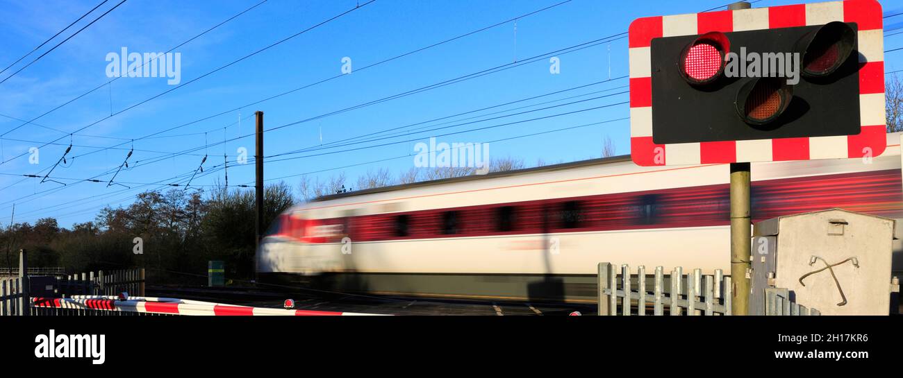 Treno Azuma che passa luci rosse a un incrocio senza equipaggio, East Coast Main Line Railway, Peterborough, Cambridgeshire, Inghilterra, Regno Unito Foto Stock