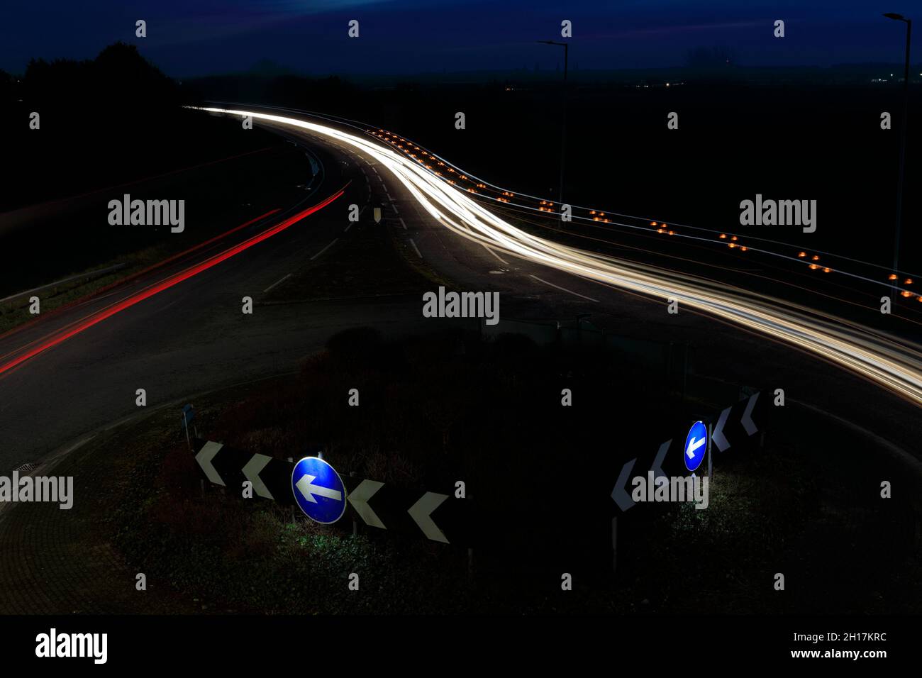 Percorsi per auto notturne a una rotatoria, Peterborough City, Cambridgeshire, Inghilterra; Regno Unito Foto Stock