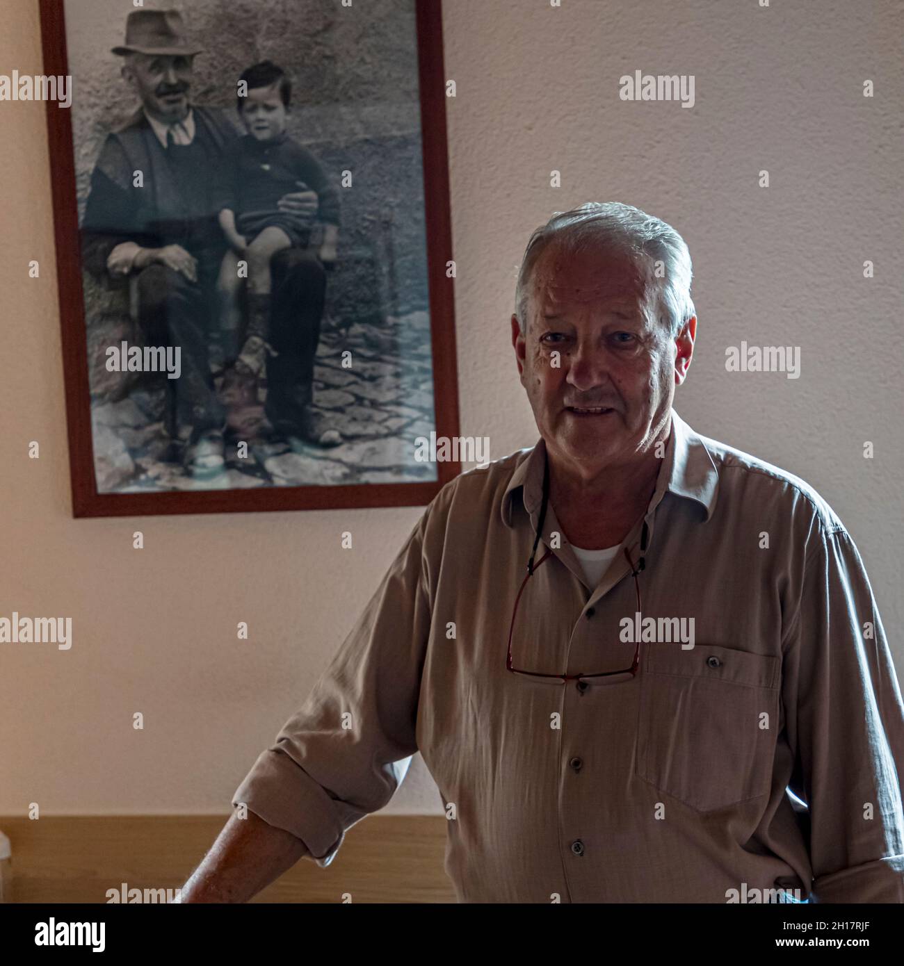 Gearino Pifaretti, proprietario di Osteria Manciana davanti alla foto che lo mostra con il nonno, Breggia, Svizzera Foto Stock