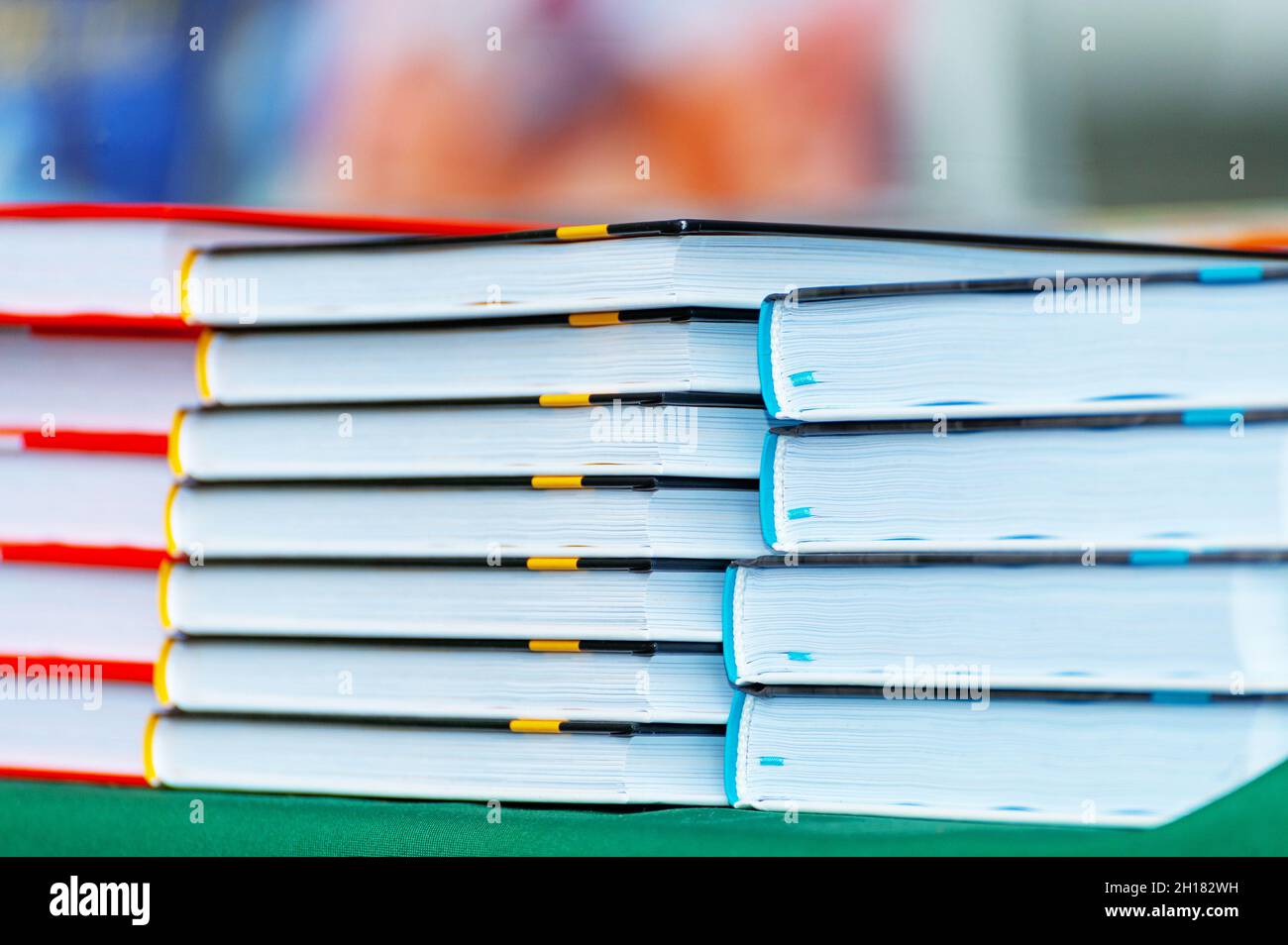Pila di nuovi libri sul tavolo. Libri sul forum dei produttori di prodotti stampati. Foto Stock