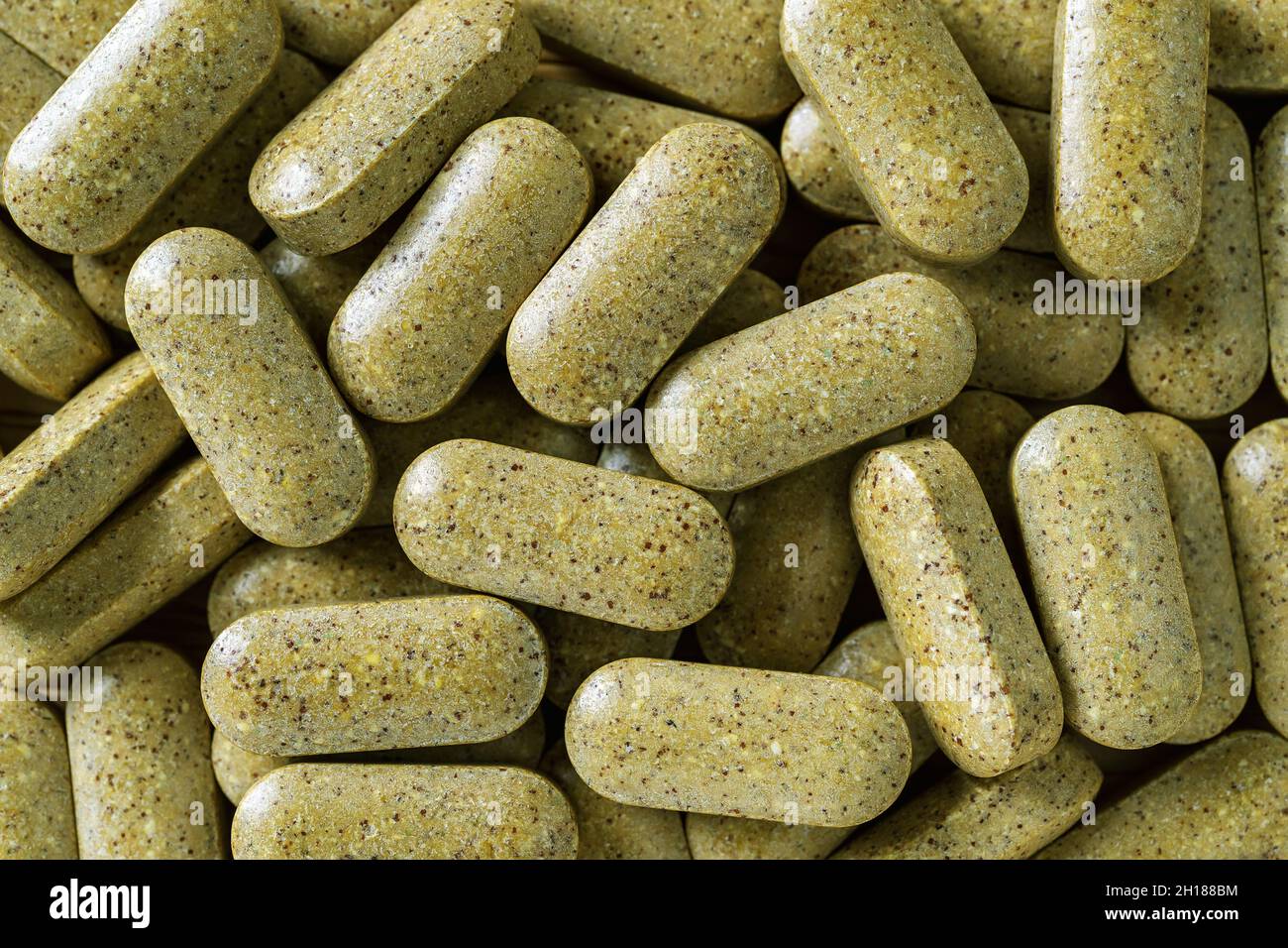 Pillole multivitaminiche ogni giorno heap macro sfondo. Pila di erbe giornaliere verde compresse texture. Integratori alimentari medici, concetti di medicina a base di erbe. Foto Stock