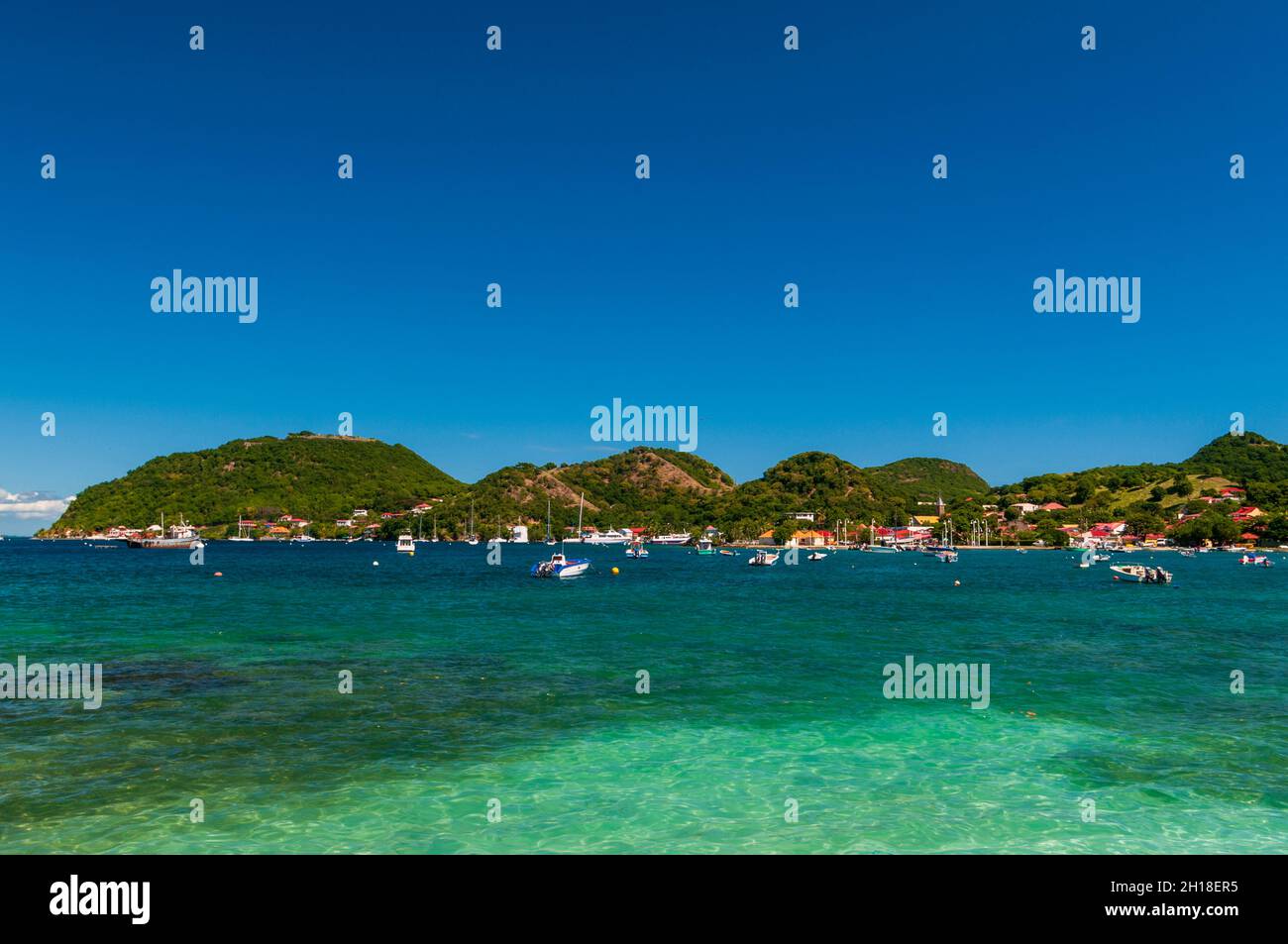 Barche ancorate nei Caraibi al largo della costa di le Bourg. Terre de Haut, Iles des Saintes, Guadalupa, Indie Occidentali. Foto Stock