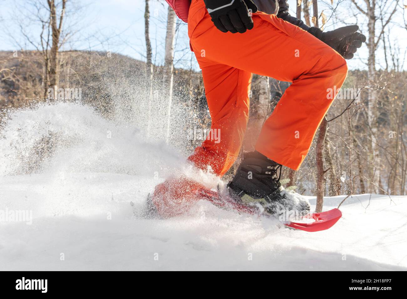 Racchette da neve che camminano nella neve. Primo piano di gambe di atleta uomo che corre in bianco polvere profonda neve racchette da neve indossando scarpone da neve Foto Stock