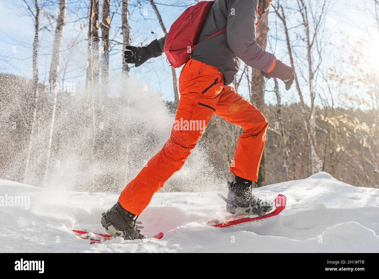 Sport invernali attività all'aperto uomo che corre nella neve in racchette da neve divertirsi nevicare all'aperto Foto Stock