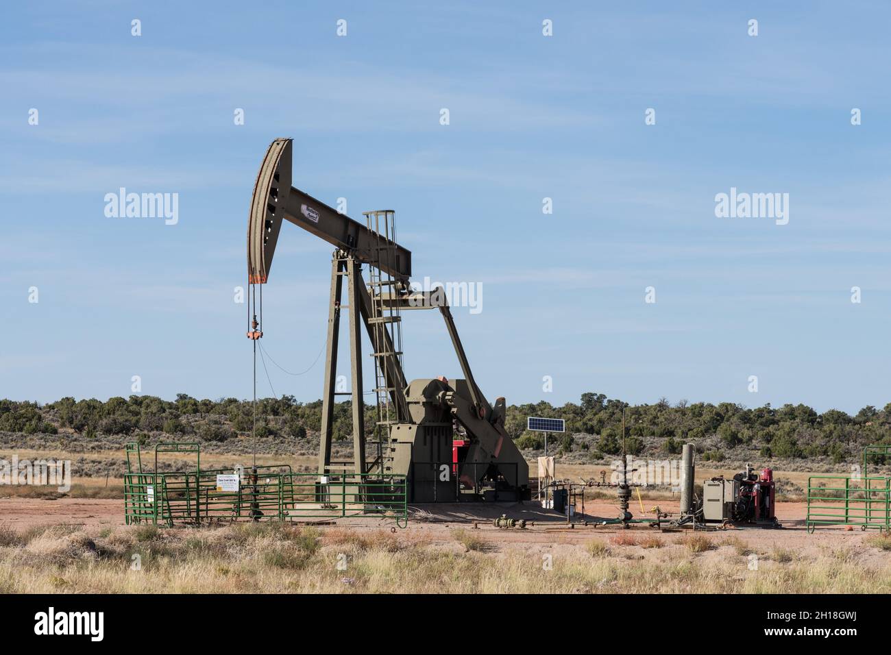 Un martinetto convenzionale per pompe di pozzi petroliferi con testa di cavallo in un sito di pozzi petroliferi nello Utah. Foto Stock