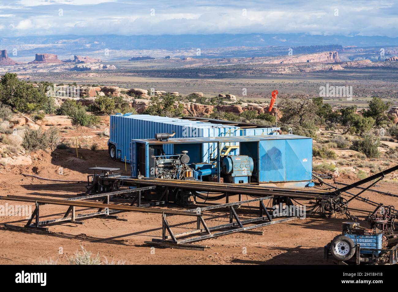 Rack per tubi, generatore elettrico diesel portatile e serbatoi di stoccaggio dell'acqua portatili in un sito di pozzi nello Utah. Foto Stock
