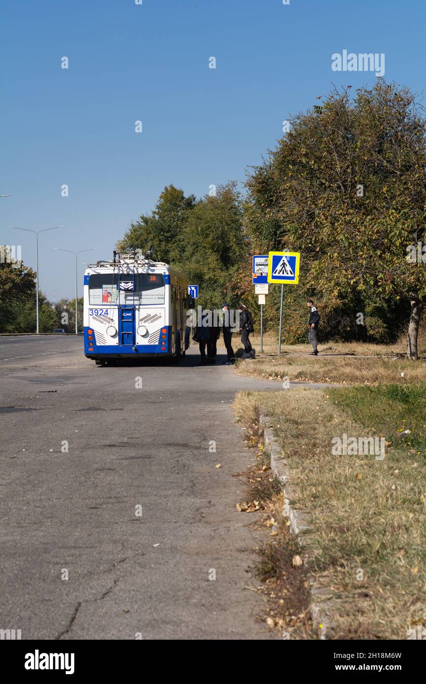 Chisinau, Moldavia - 10 ottobre 2021: Passeggeri in maschera di protezione in attesa di imbarco sul filobus elettrico durante la quarantena del virus corona. Foto Stock