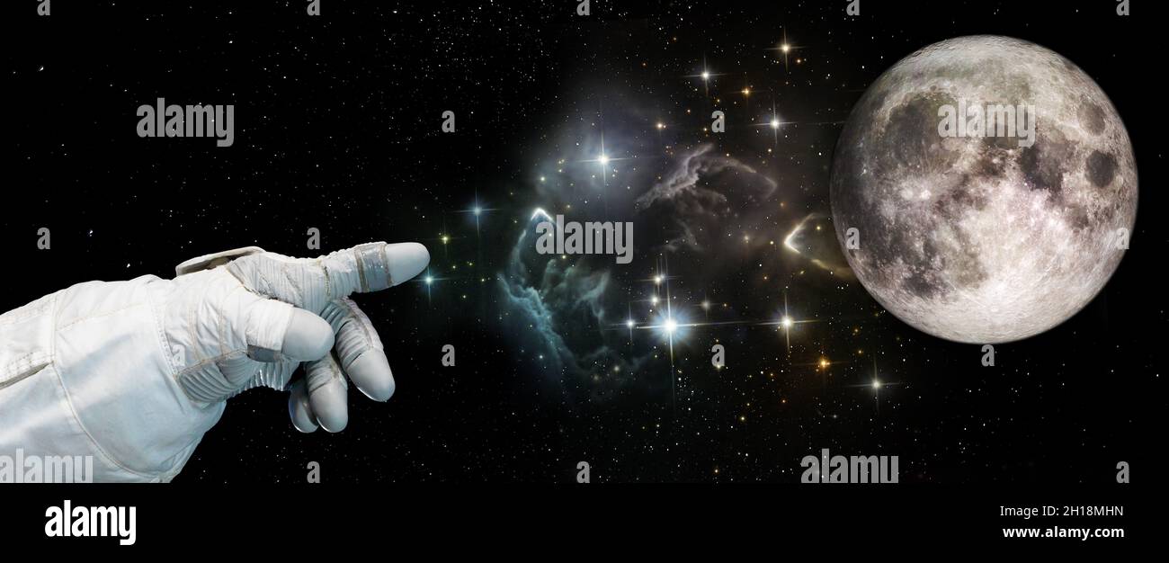 La mano degli astronauti punta verso la luna nel cielo stellato. Concetto di esplorazione della Luna e dello spazio. Elementi di questa immagine forniti dalla NASA. Foto Stock