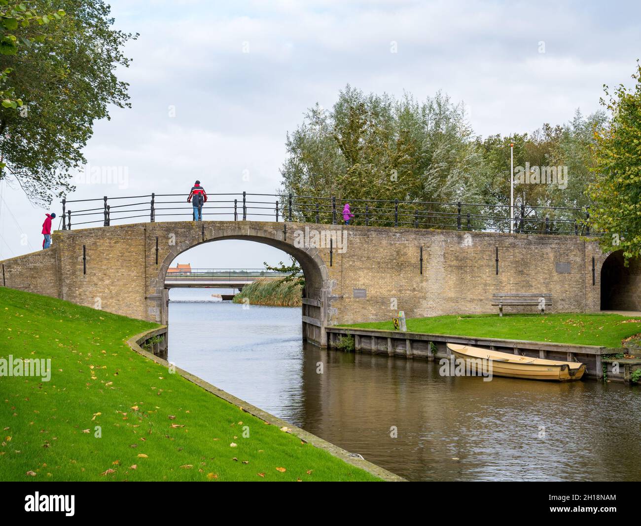 Persone che camminano sul ponte di Woudsender Water gate nella città di Sloten, Sleat, Friesland, Paesi Bassi Foto Stock