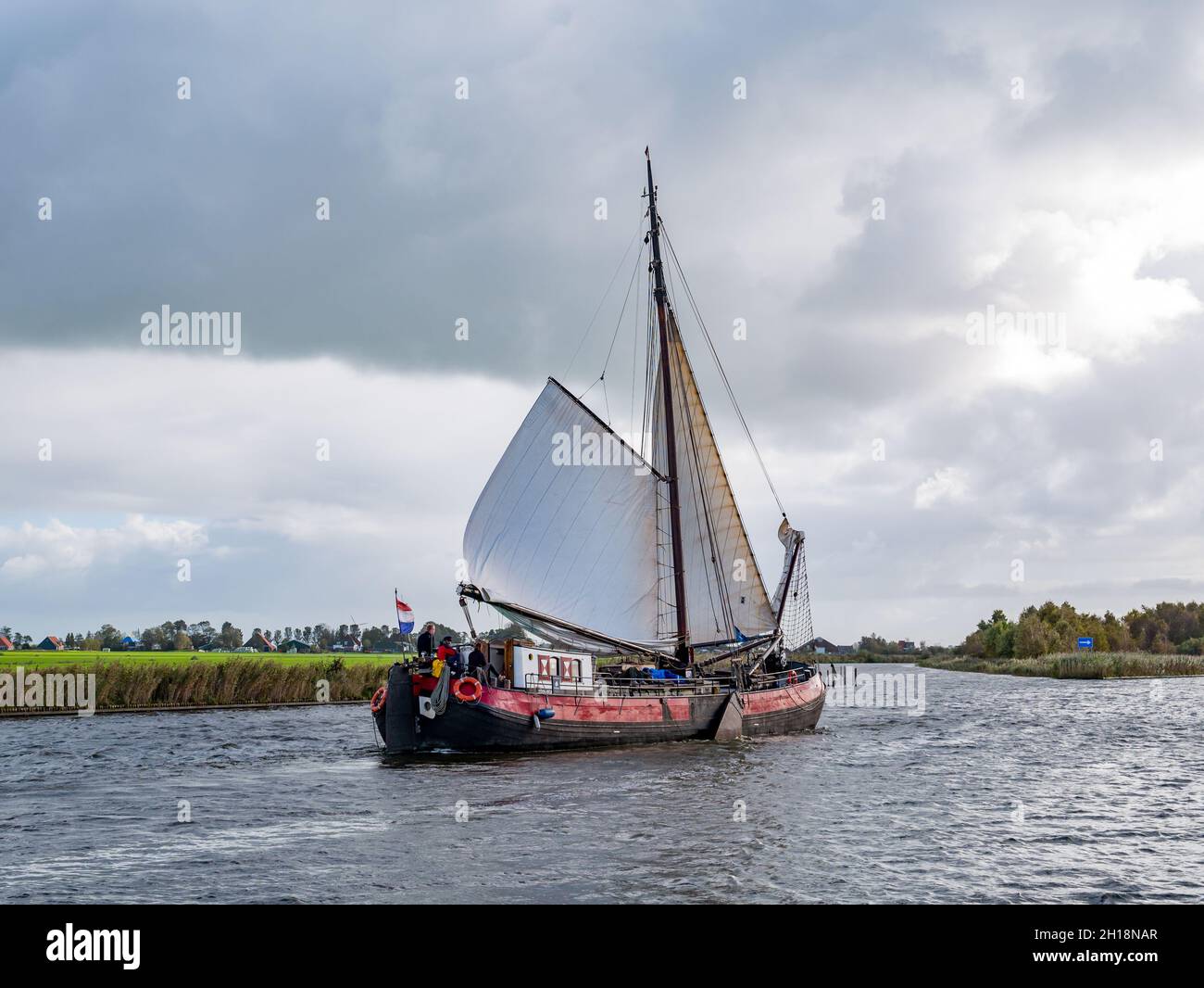 Persone che navigano in barca a vela tradizionale a Jeltesloot a De Fryske Marren, Frisia, Paesi Bassi Foto Stock