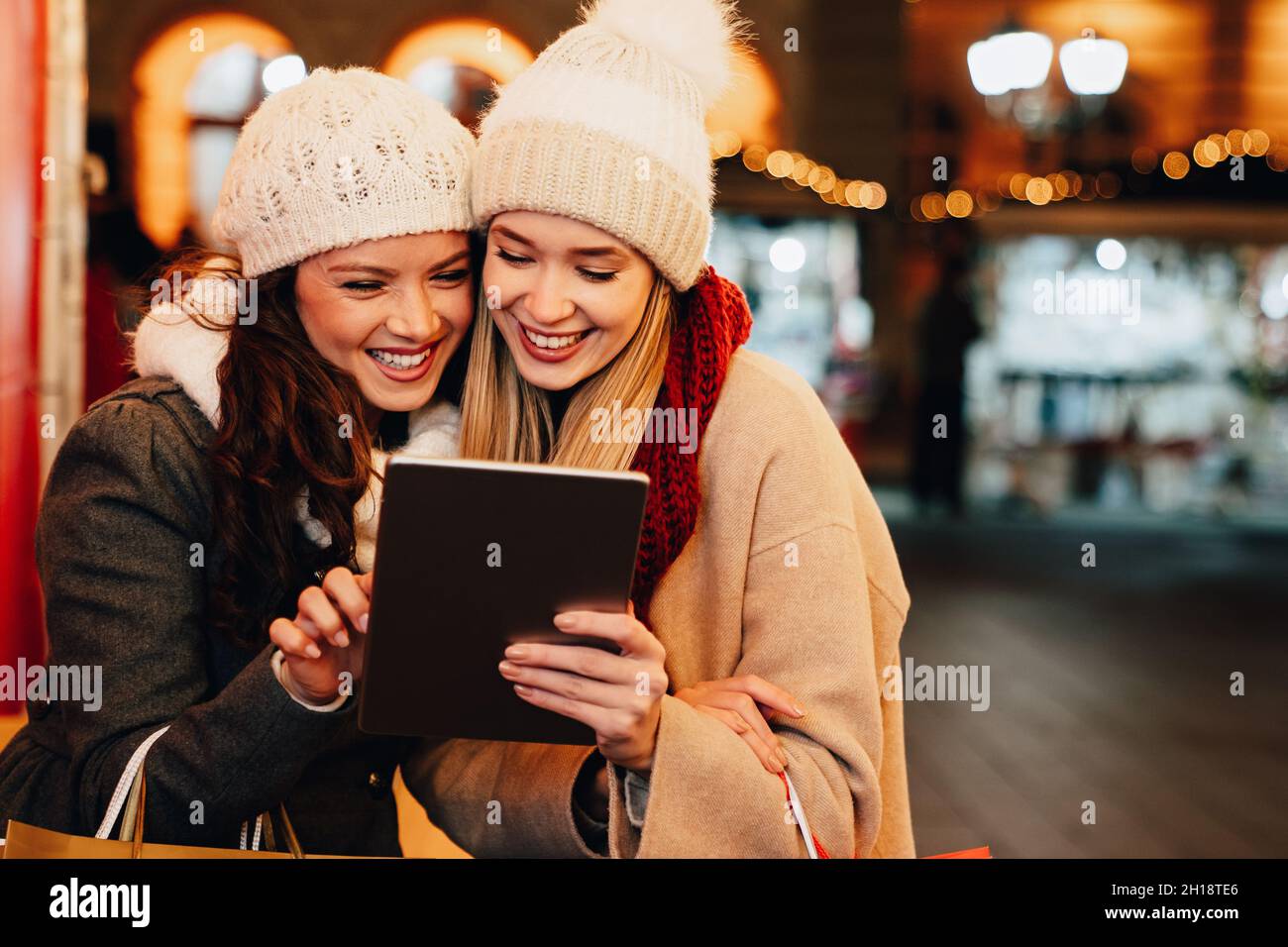 Natale Happy People concetto di tablet digitale. Buone donne amici che si divertano a fare shopping in città Foto Stock