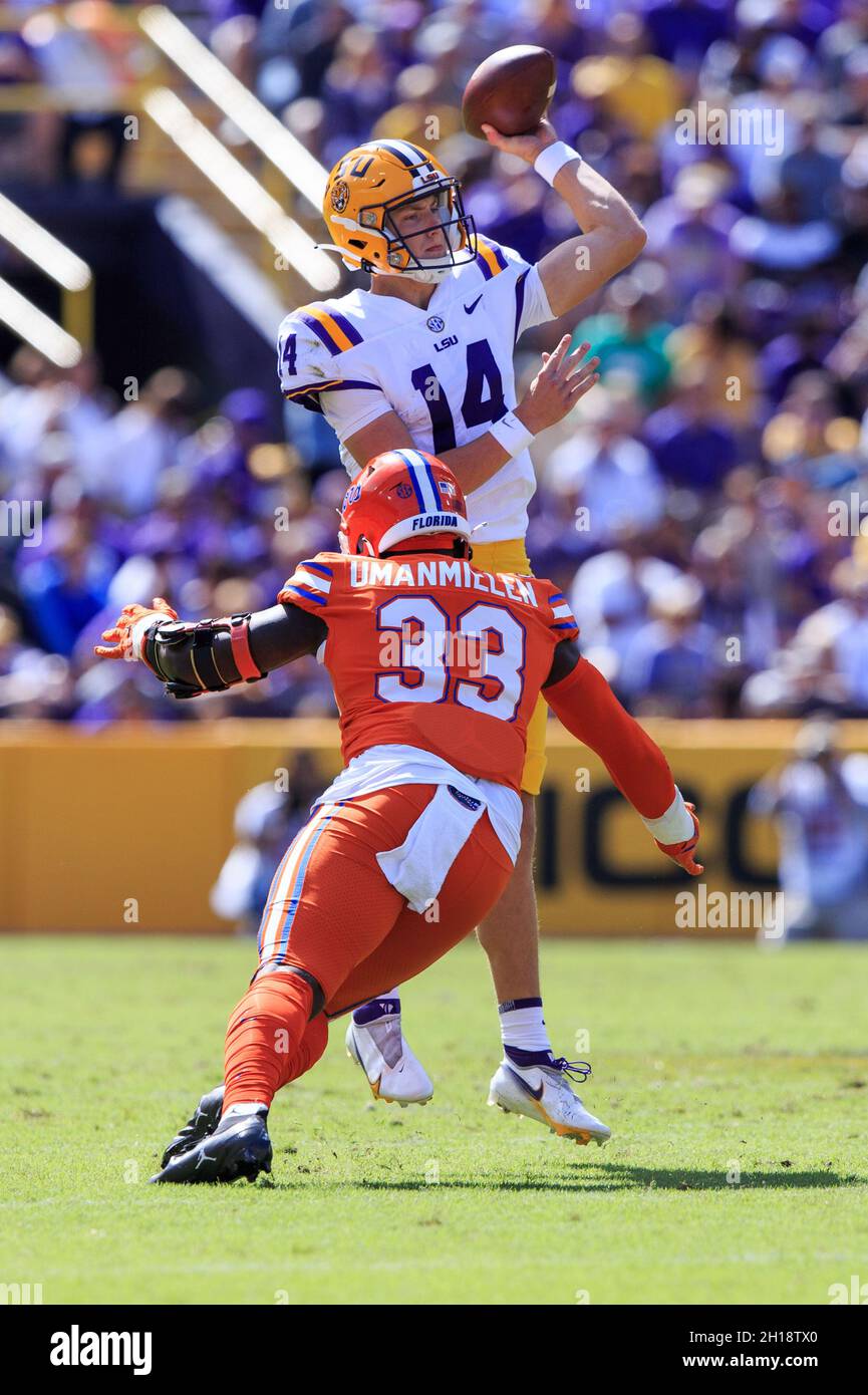 LSU Tigers quarterback Max Johnson (14) passa mentre la pressione da Florida Gators difensivo lineeman Princely Umanmielen (33), Sabato, 16 ottobre 2021 Foto Stock