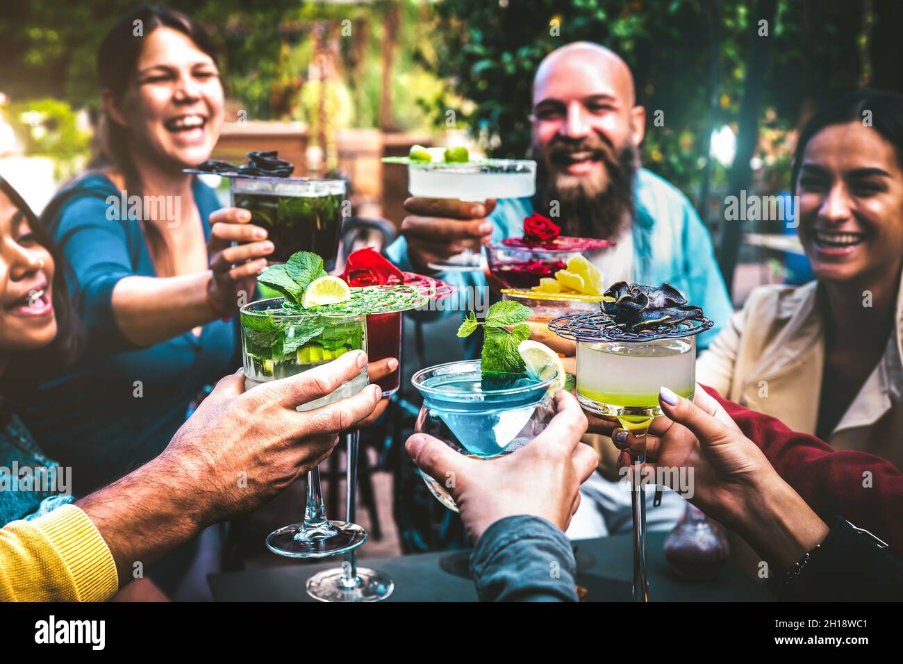 Gente alla moda che tiene bevande multicolore - amici alla moda che si divertono insieme a bere cocktail all'happy hour - festa sociale di riunione Foto Stock