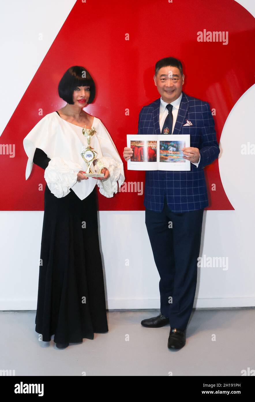 Manhattan Beach, California, Stati Uniti. 15 ottobre 2021. Homeira Goldstein, presidente del consiglio di amministrazione del Manhattan Beach Art Center, con il suo Los Angeles Beverly Arts (LABA) Icon Charity Award presentato da Joey Zhou ospite della TV che tiene il suo dono di un libro di Jiannan Huang artista del chip blu di LABA, Al TIME4ART Exhibition con l'artista David A. Peters al Manhattan Beach Art Center di Manhattan Beach, California. Credito: Sheri Determan Foto Stock