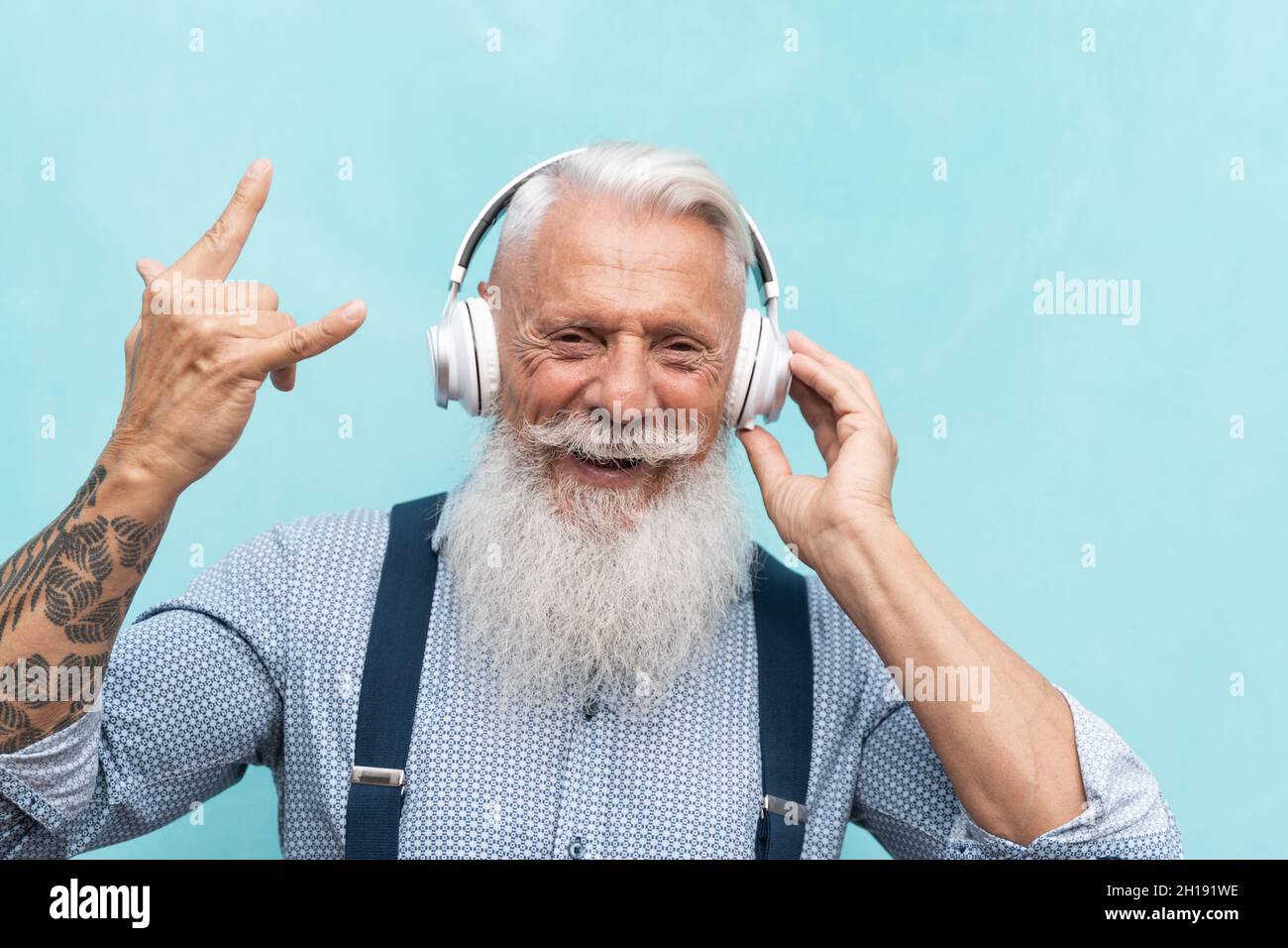 Uomo hipster senior che ascolta musica rock playlist con cuffie - persone anziane che godono di tecnologia Foto Stock