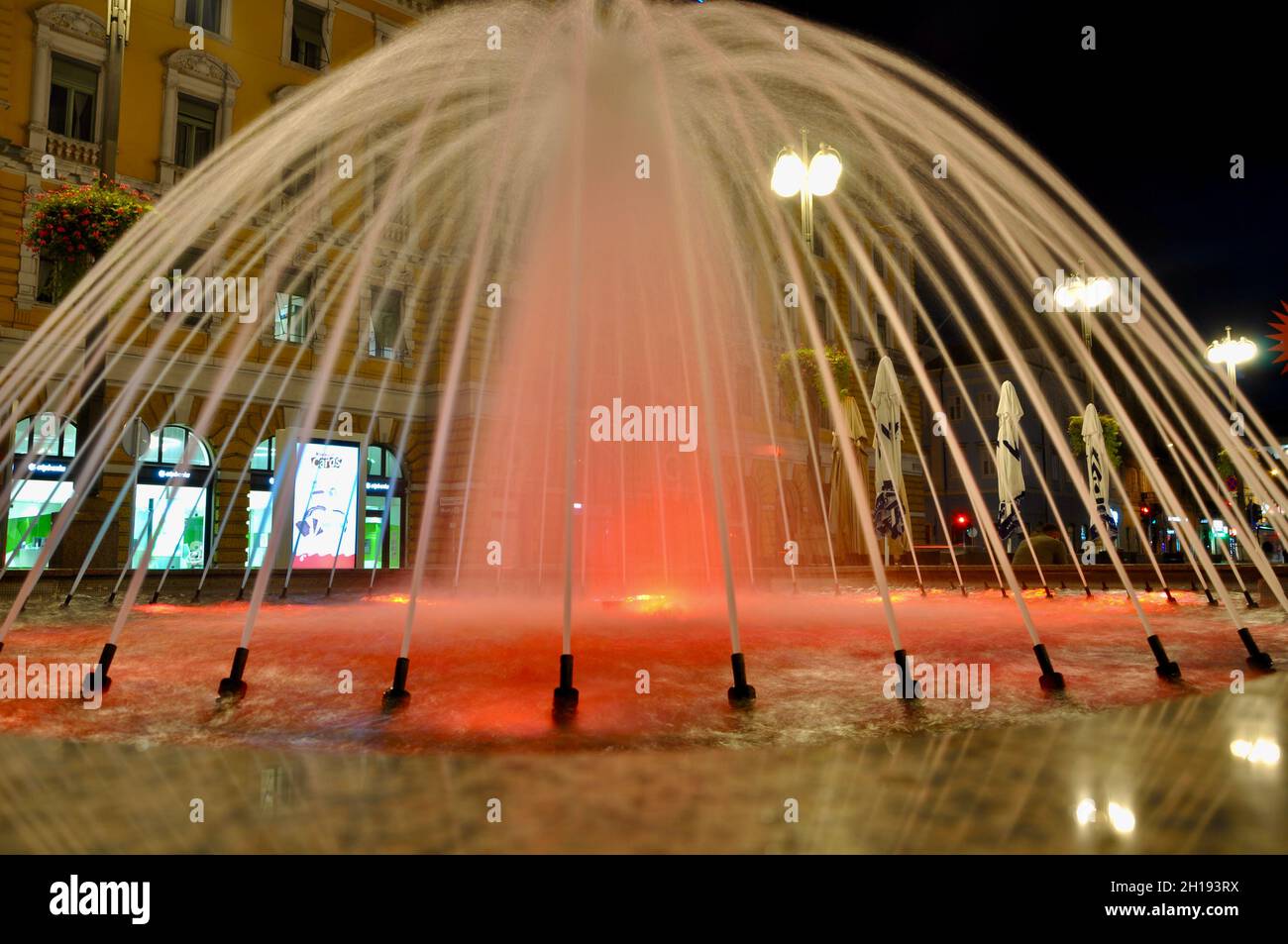 Fontana varicolorata sulla piazza di notte. Foto Stock