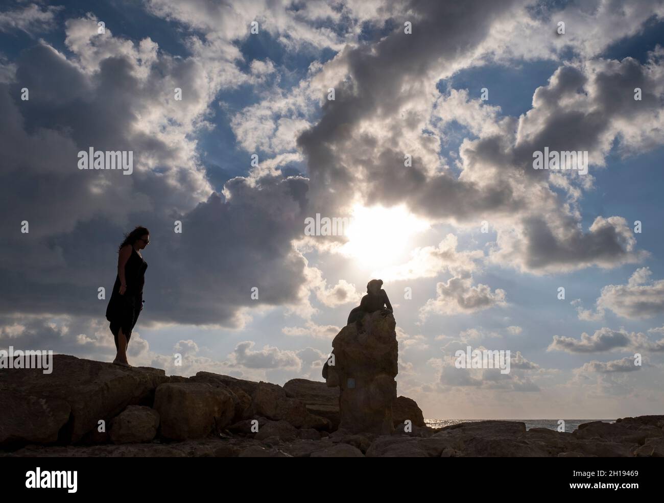 Una donna guarda “Sol Alter”, una scultura in bronzo di Yiota Ioannidou, la scultura si trova vicino al Forte di Paphos, Paphos, Cipro. Foto Stock