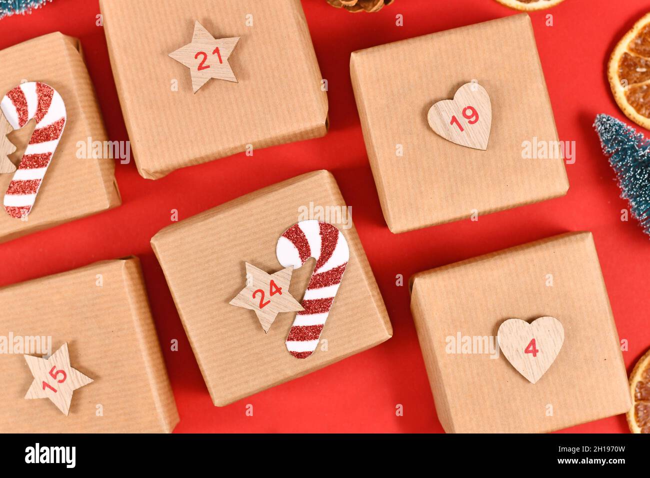 Calendario dell'Avvento fatto in casa da scatole di carta artigianale su sfondo rosso Foto Stock