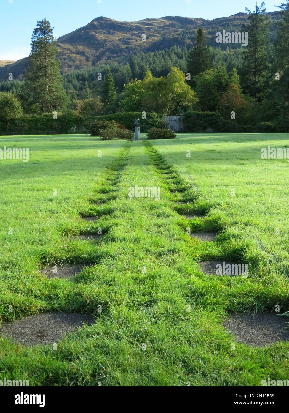 Vista del Giardino murato e pietre a gradini affondate fino alla sfera commemorativa dell'Armillario nelle Highlands scozzesi, ambientazione del Giardino Botanico di Benmore Foto Stock