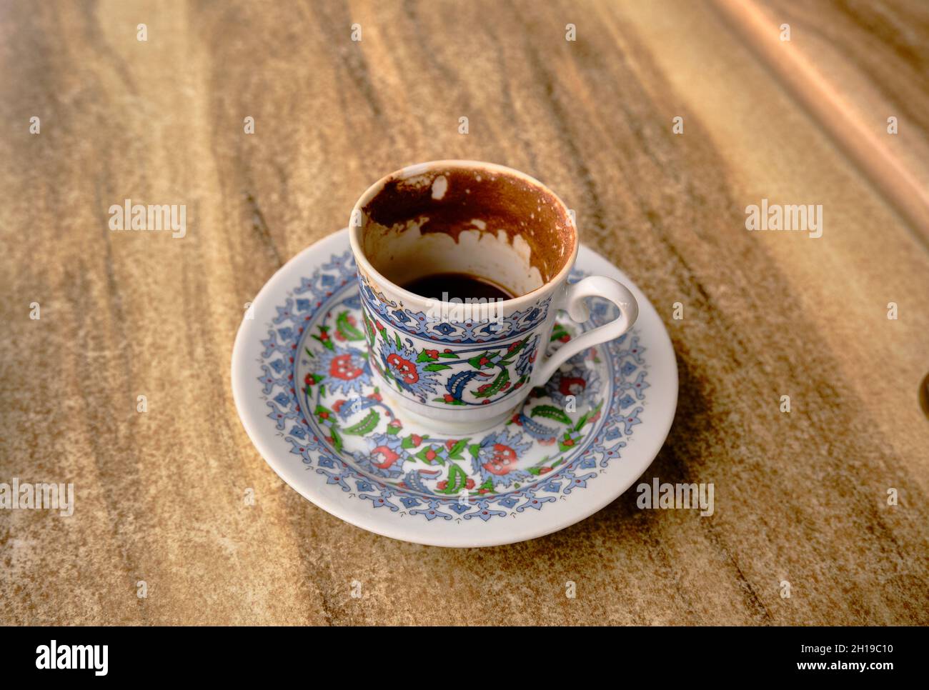 Tradizionale caffettiera turca e piatto con ghiaia iznik sulla tazza in caffè e tavolo in legno. Foto Stock