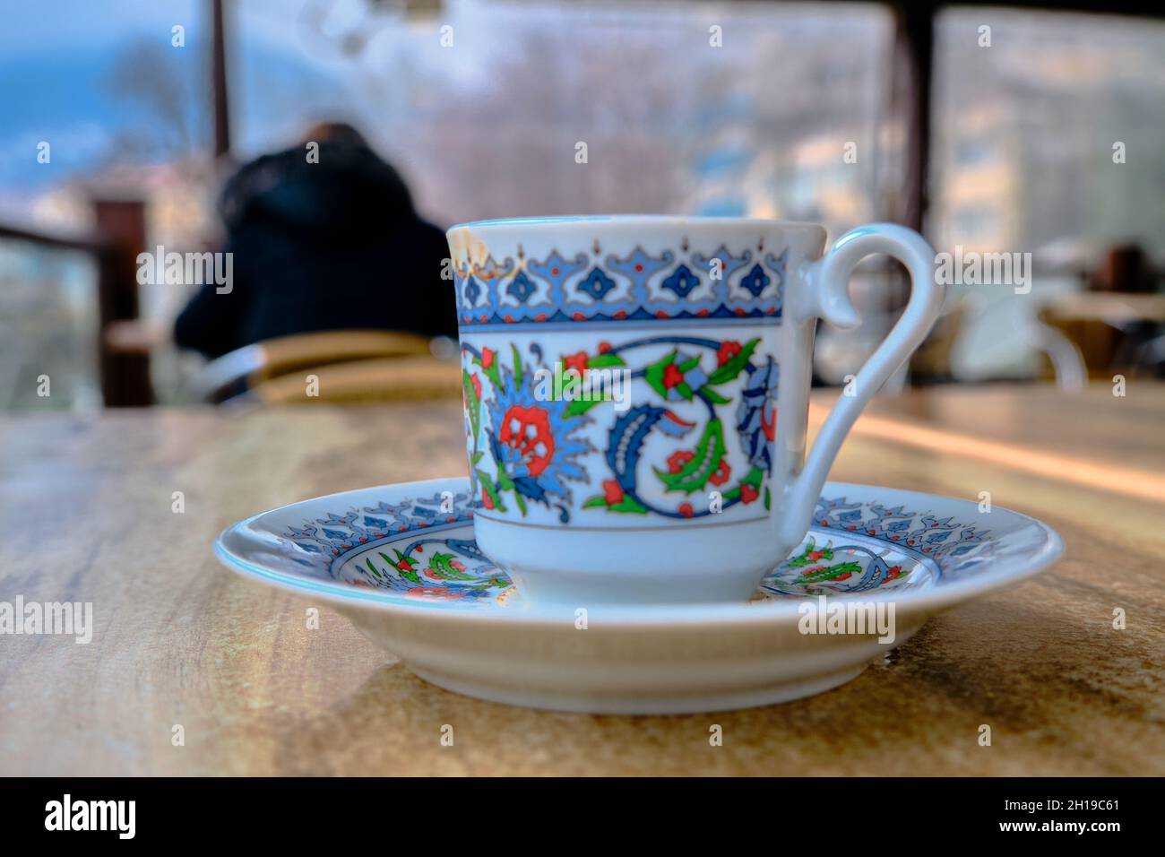 Tradizionale caffettiera turca e piatto con ghiaia iznik sulla tazza in caffè e tavolo in legno. Foto Stock